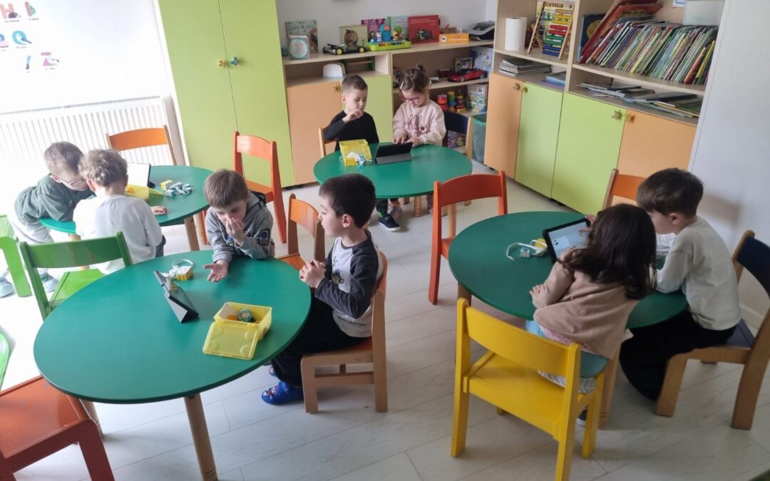 Copii lucrând în echipă la un proiect de robotică