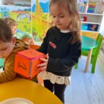 Copii aruncă zarul educativ pentru învățarea cifrelor 1 2 și 3 la Grădinița Don Castor București
