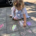 Copii implicați în activități de educație prin joc și desen pe asfalt la Grădinița Don Castor din București.